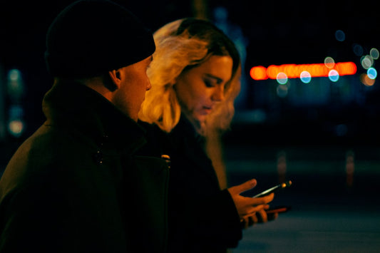 a man and woman looking at a cell phone
